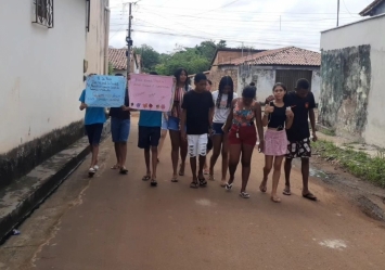 Adolescentes do Projeto Vamos! distribuem panfletos informativos sobre o dia 18 de maio.